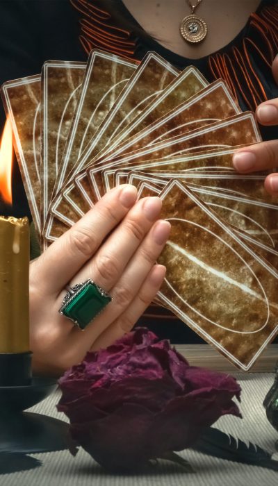 Tarot cards on fortune teller desk table. Future reading. Woman fortune teller holding and hands a deck of tarot cards.